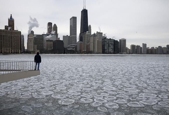 Image: Charles Martinez looks over the partially frozen Lake Michigan and the Chicago skyline,