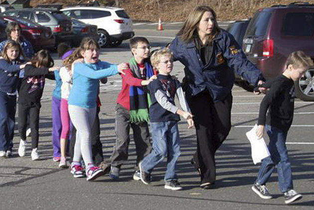 Students from Sandy Hooks Elementary School in Newtown, CT are being escorted out of the school by a police officer.
