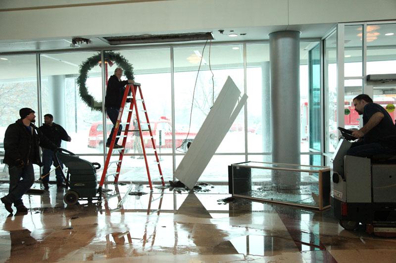 Central janitors respond to the burst pipe at the main entrance of the building caused by the extremely low Naperville temperatures.