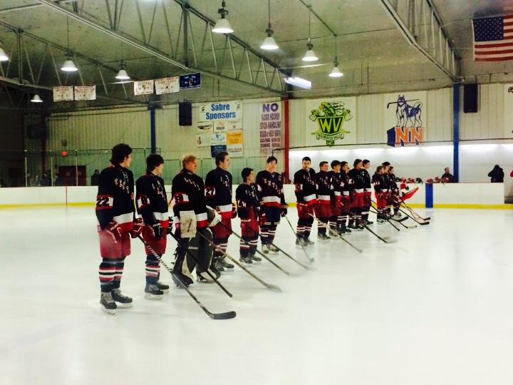 The Varsity Redhawk players listen to Central junior Brianna Reilly sing the national anthem before the start of the game.