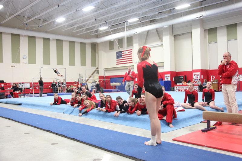 Senior Emily Hufferd anticipates her vault as her teammates watch on.