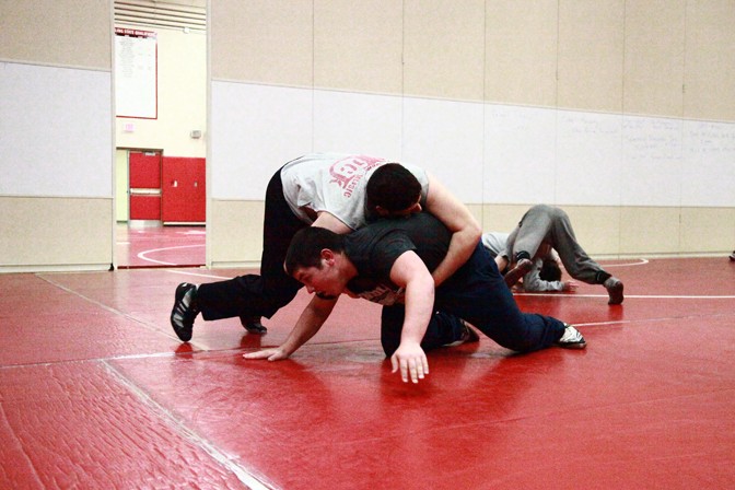 Senior Hayden Saldivar attempts to pin down sophomore Christian Nussbaum during practice.