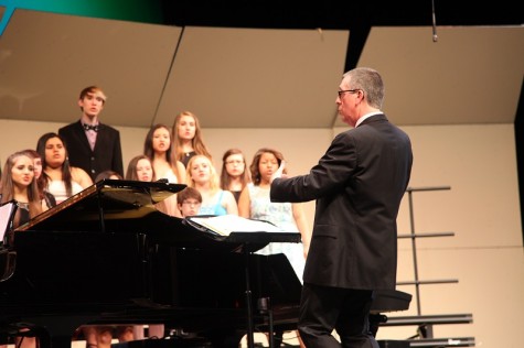 Choir director Curt Parry directs one of the choirs at his final concert.