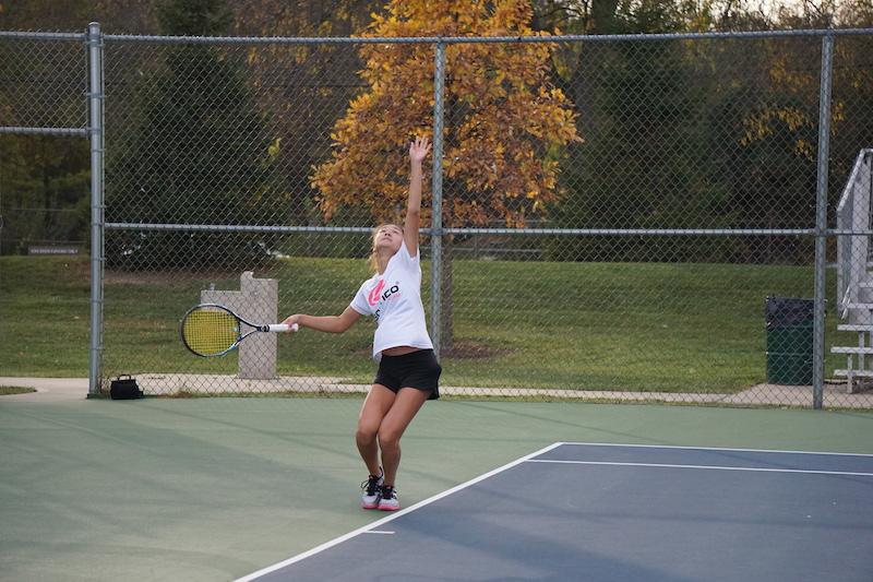 Tennis+captain+Tiffany+Chenn+sets+up+a+serve+at+tennis+practice.