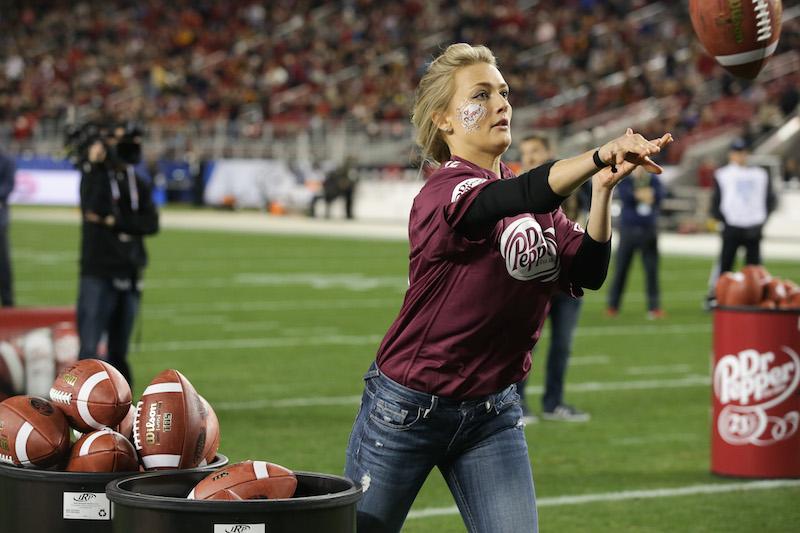 Central alumna Kotryna Staputyte tosses footballs into an oversized Dr. Pepper can to compete for a $100,00 scholarship.