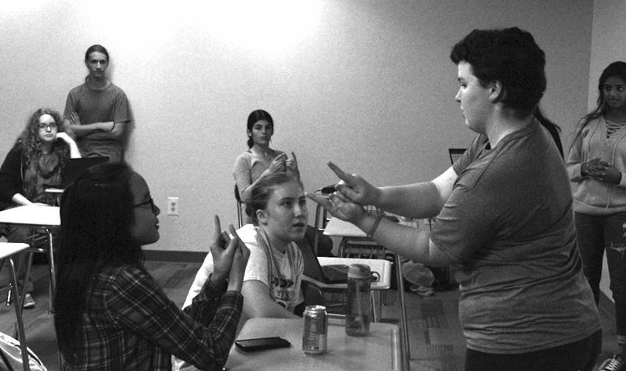 Junior+Catherine+Henkel+teaches+sign+language+to+juniors+Karis+Li+and+Emma+Apicella.