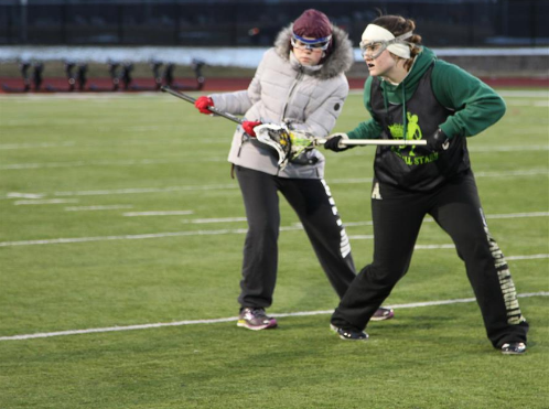 Two girls lacrosse players fight for the ball in March 2016.