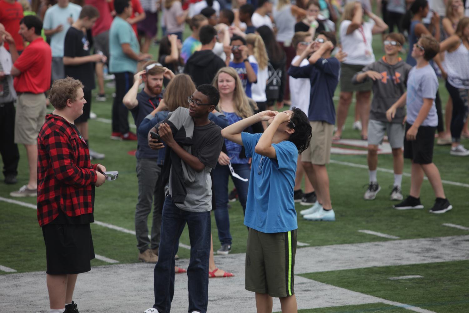 Students use their special solar eclipse glasses to view the sun during the eclipse.