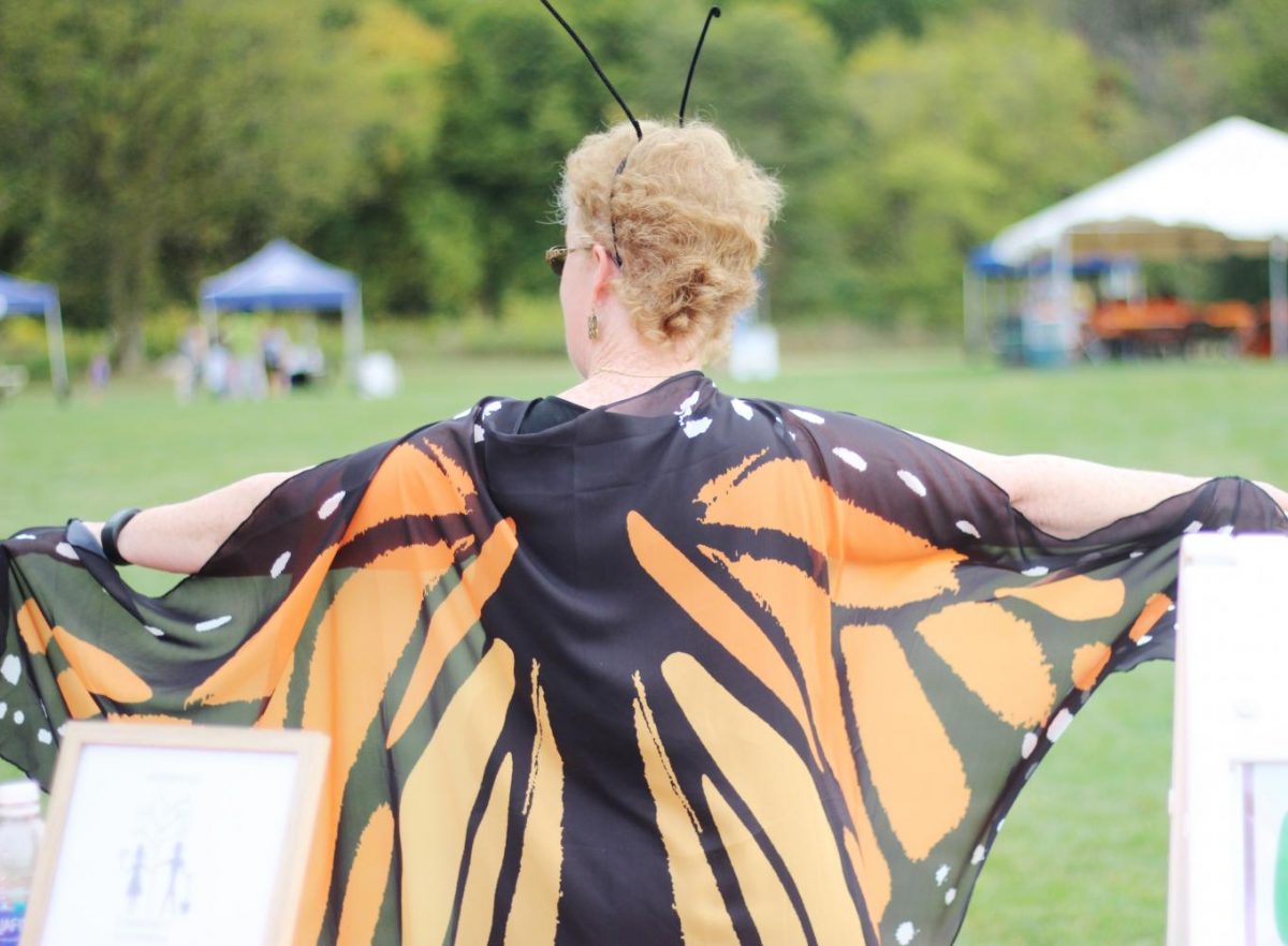 A volunteer greets children and families as they enter the Monarch Festival.