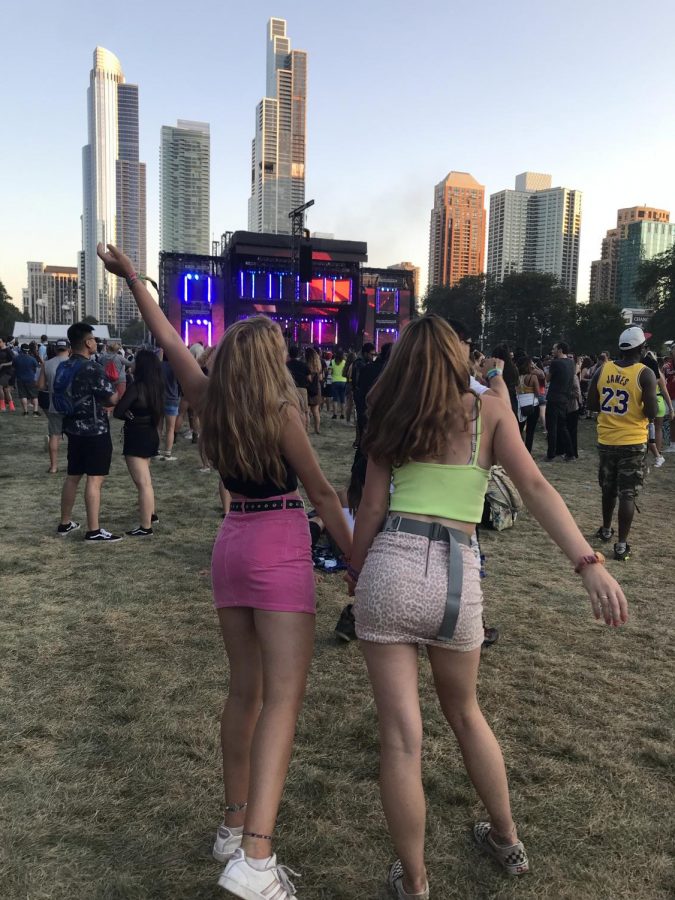 Emme Moore and her friend, Morgan Olefsky, pose in front of the city skyline at Lollapalooza 