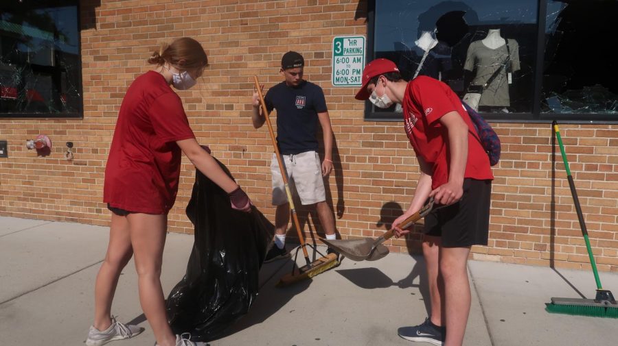 Naperville teens work together to sweep up broken glass caused by Monday night vandals.