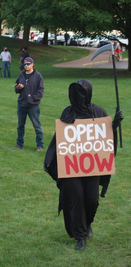 Not everyone in attendance at Mondays rally was in favor of reopening schools. One parent warned of reopening by appearing in costume dressed as the Grim Reaper. 