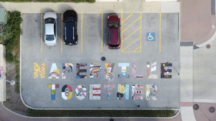 The 'NAPERVILLE TOGETHER' sidewalk art can be found on Water Street in downtown Naperville.