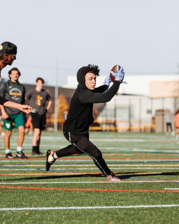 Naperville Central High School junior and varsity running back Antonio Torres makes a run after receiving the ball in a non-school sanctioned seven-on-seven practice camp against Waubonsie Valley High School at the Knoch Park multipurpose turf field in Naperville.