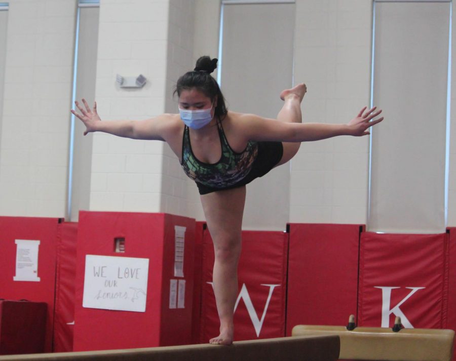 Junior varsity gymnast Anna Chi works on her form in preparation for her balance beam routine during practice at Naperville Central High School on Feb. 12.