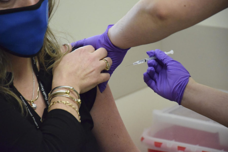 A nurse at the DuPage County Health Department prepares to vaccinate a department safety officer.