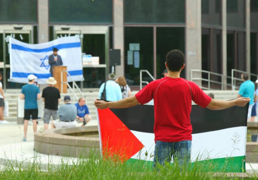 A Palestinian counter protester silently holds a Palestinian flag at the "Walk for Israel" rally on May 23 at Naperville City Hall.