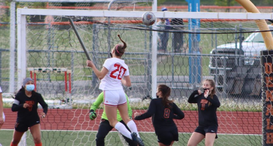 Sophomore varsity center back Ella Burke buries a header into the goal off of a corner kick from junior varsity outside back Sam Sharp against DeKalb High School on May 4.