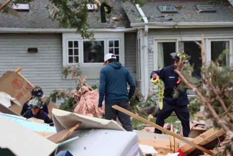 Firefighters help a resident scour for personal items in the debris caused by a tornado that touched down in Naperville on the night of June 20. 