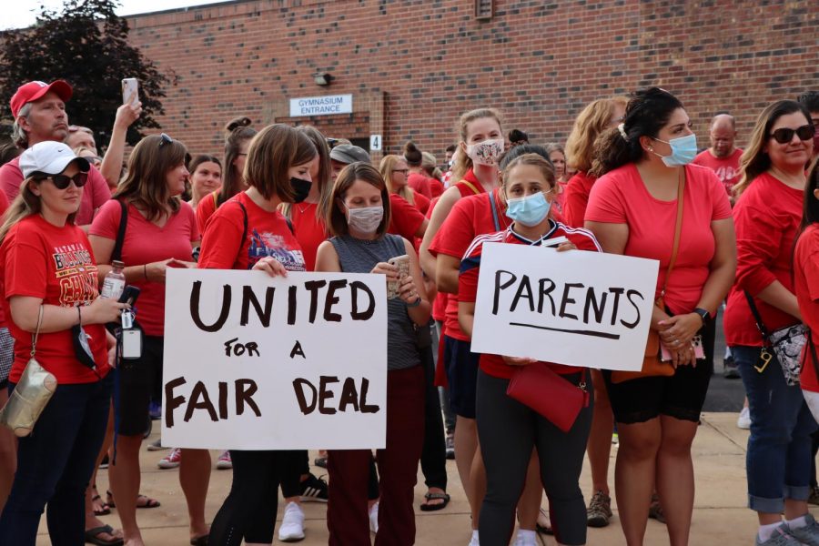 Educators, parents and students rally outside of the Washington Junior High School main entrance in support of the Naperville Unit Education Associations contract proposal on Aug. 2. 