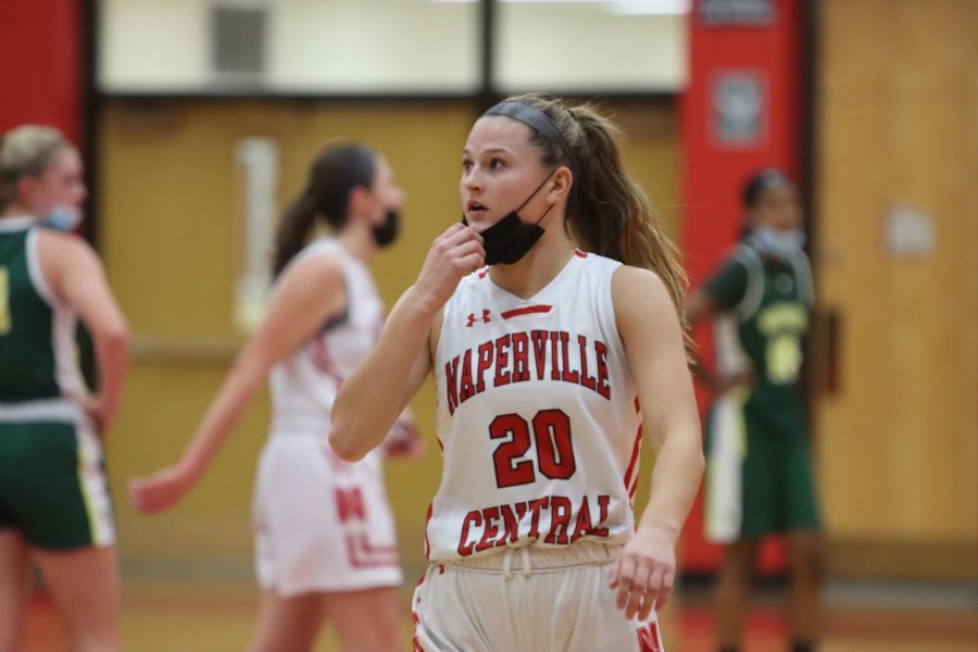 Naperville Central junior forward Ella Burke adjusts her mask in between plays against Waubonsie on Dec. 2 at home.