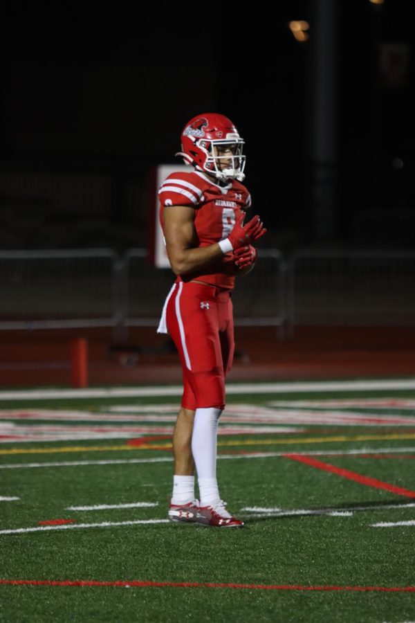 Senior Reggie Fleurima gets ready to return a kickoff against Naperville North on Oct. 8.