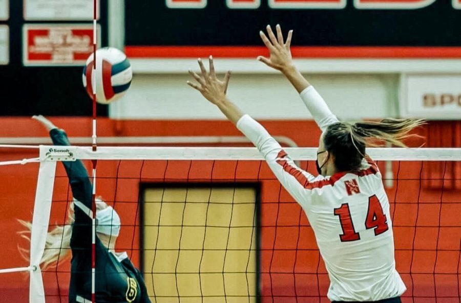 Senior Kenzie Brower blocks a slam against conference opponent Waubonsie Valley.