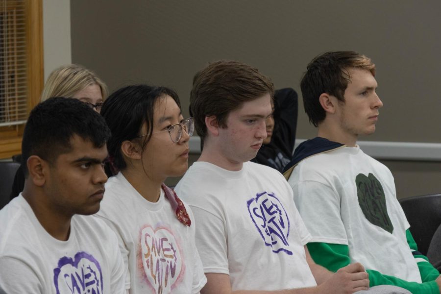 From left: Central students Nihal Kaki, Athena Chen, Declan O’Donovan and Jack Campbell wear shirts with “Save Latin” on them at the District 203 Board of Education meeting on Oct. 17.  