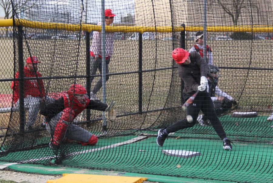 Senior Clay Schrader practices batting in the cage with junior catcher Danny Vogel