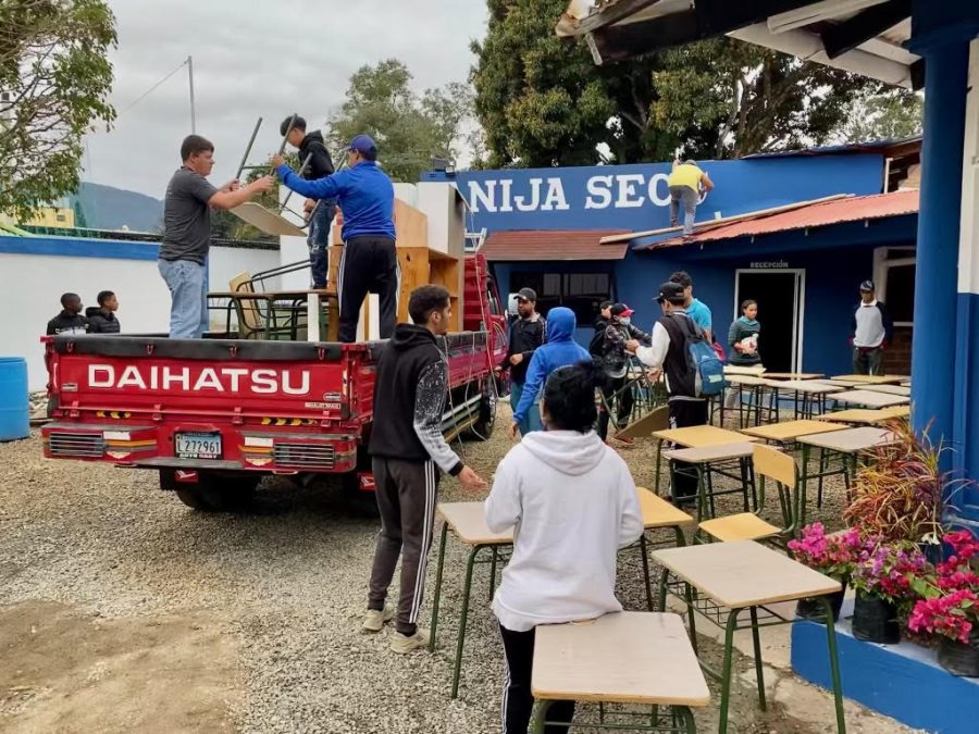 Students from Aniji school move their desks from the original campus to the new one.
