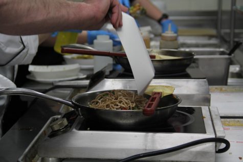 Aramark employees cook stir fry to be served to Central students on May 2. Aramark is set to be replaced by OrganicLife as District 203s food service provider on July 1, 2023. 