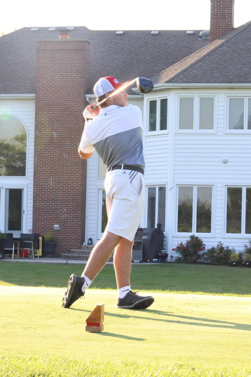 Senior Matt Sims hits the ball down the fairway in the match against Naperville North on Sept. 14. 