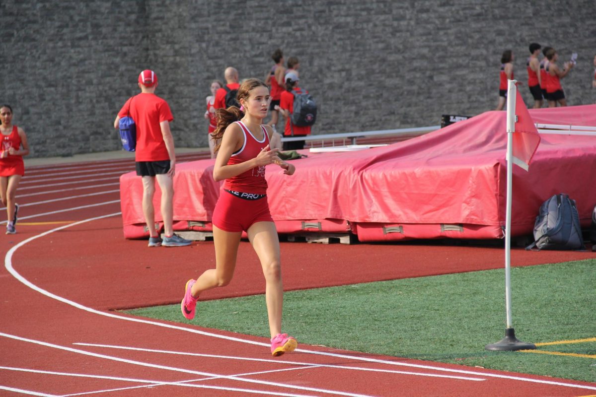 Girls cross country runner and senior Ava Hendren nears the finish line at her teams race during Centrals Red and White Night. 