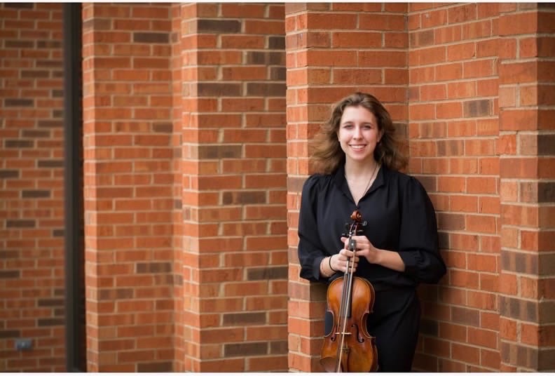 Kiersten Scherer, a Central senior, busks on the streets of Downtown Naperville. She once made $260 in one day. When she isn't busking, she may be performing in concert halls or walking through Central's halls.