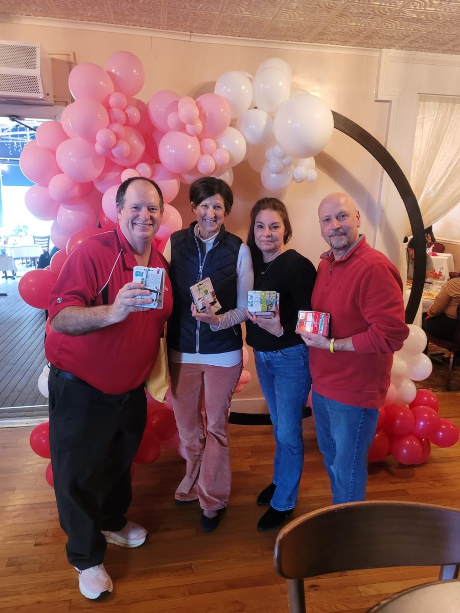 Every year, communication arts teacher Barry Baldwin (left) drops off gift cards to Holly Buckendahl (middle left), the CEO of The Ronald McDonald House Charities of Chicagoland and Northwest Indiana, with the help of Cathy Wegner (middle right) and Ed Wegner (right), parents of Justin Wegner, an alumnus who started the drive.