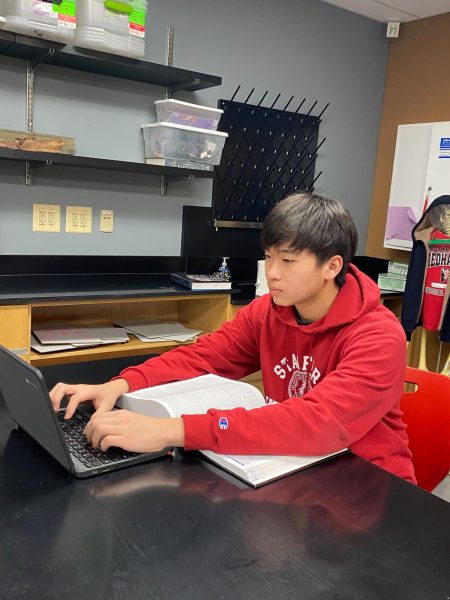 Freshman Ryan Kong sits wearing his red Stanford hoodie in AP Biology on March 15. Kong says biology is the one thing he can study for hours on end.