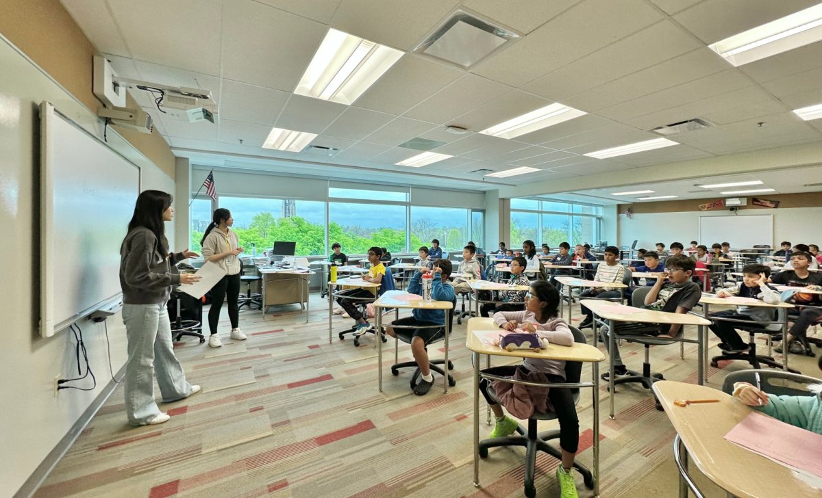 Sophomores Lilly Jia (far left) and Audrey Cheng (left) instruct competitors at Clover Math’s elementary and middle school math competition, hosted at Central on April 26. Clover Math is an organization founded by four District 203 juniors. 