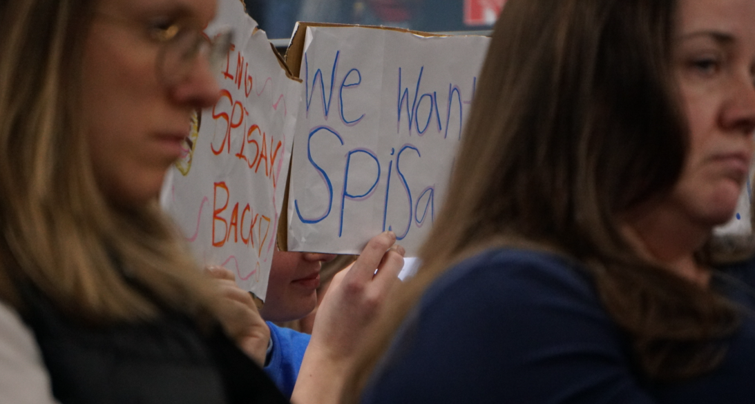 Kennedy Middle School students hold up signs supporting their teacher, Mr. Spisak. Dozens of students spoke during public comment about connections they've built with influential teachers on the RIF list, some of which also include Central's Maria Connell and North's Will DeBolt.