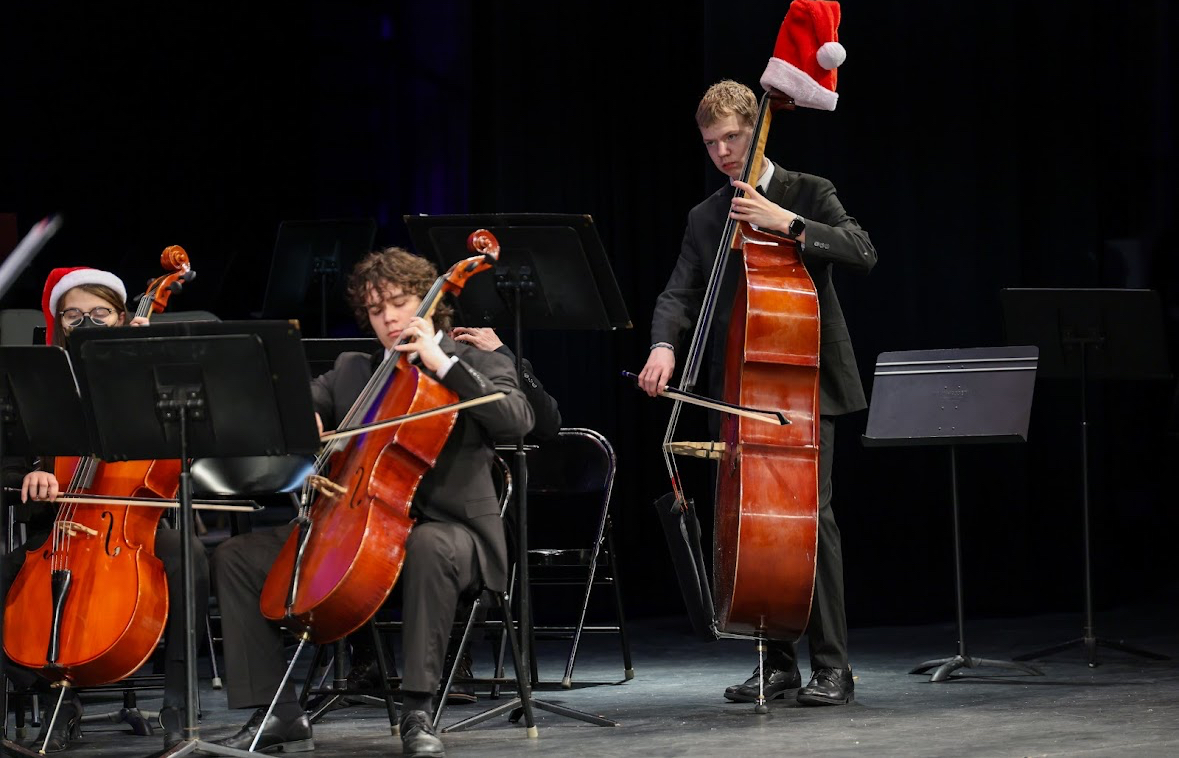 Cole Jackson (right) performing at the Winter Festival held in mid-Dec. featuring performances from the music departments. Jackson is seen playing the bass featured with a festive Santa hat for the holidays.